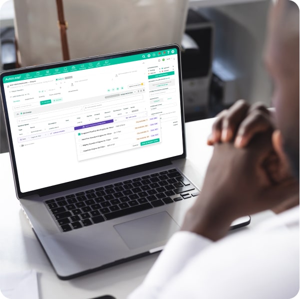 A shop owner viewing AutoLeap's dashboard on a laptop