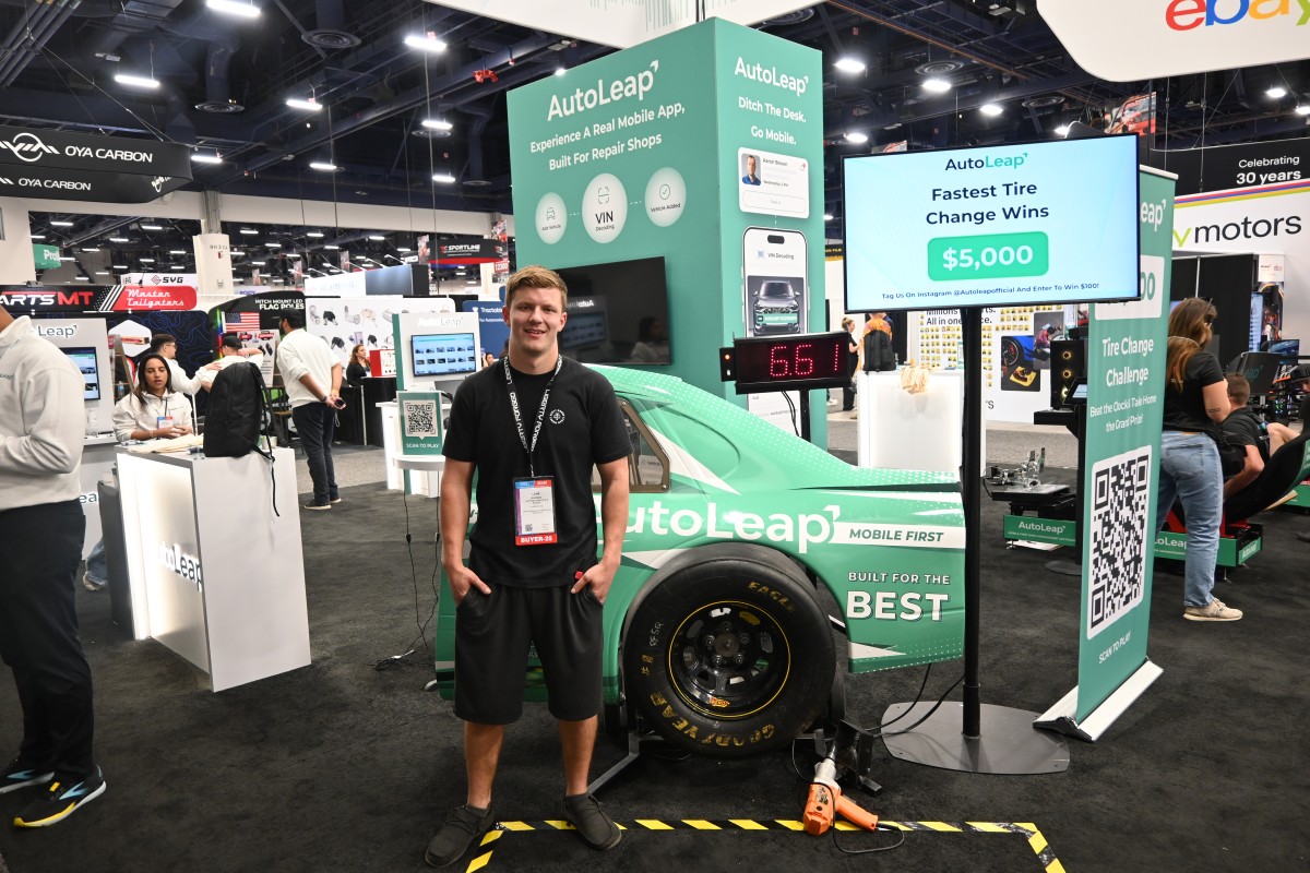 Tire Change Competition at the AutoLeap SEMA 2025 booth with a $5,000 prize and a green race car