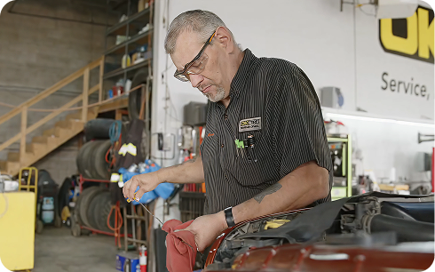 Technician servicing a tire in the bay at OK Tire