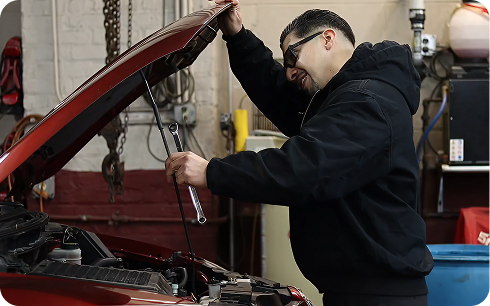 Technician at Universal Auto Care working under a car's open hood